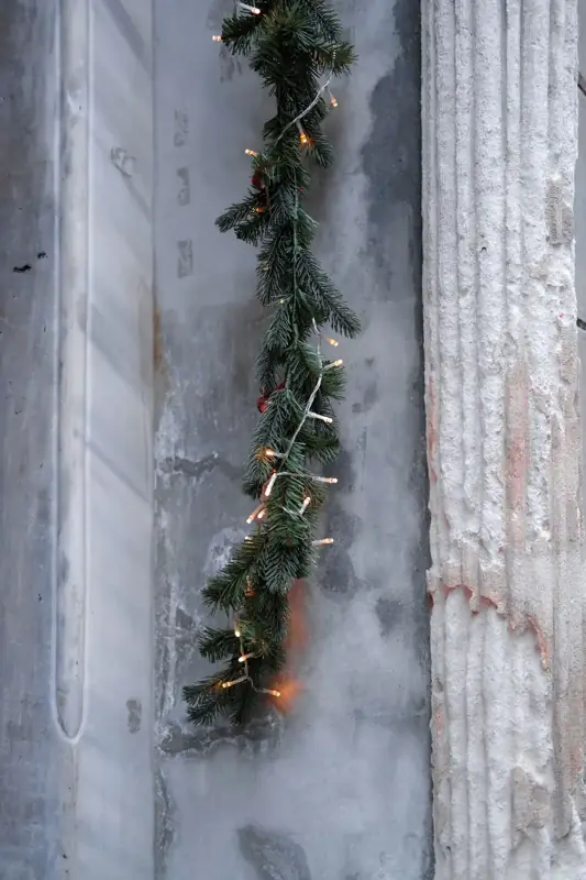 Battery operated garland wound with fairy lights on an old stone wall