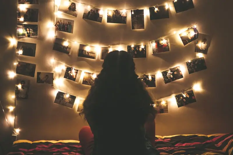 Photos clipped to fairy lights on a wall