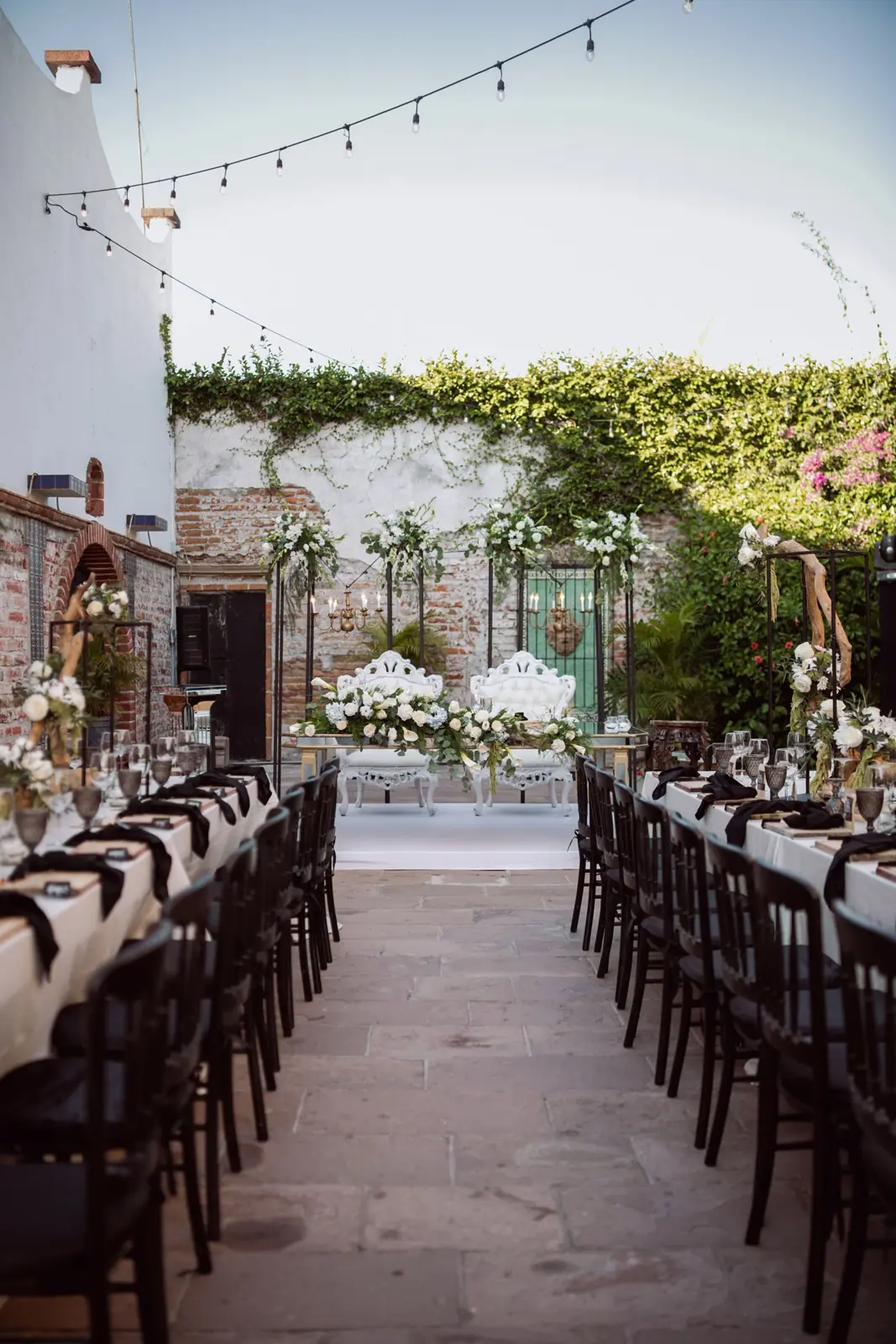 Long outdoor wedding tables with lights overhead