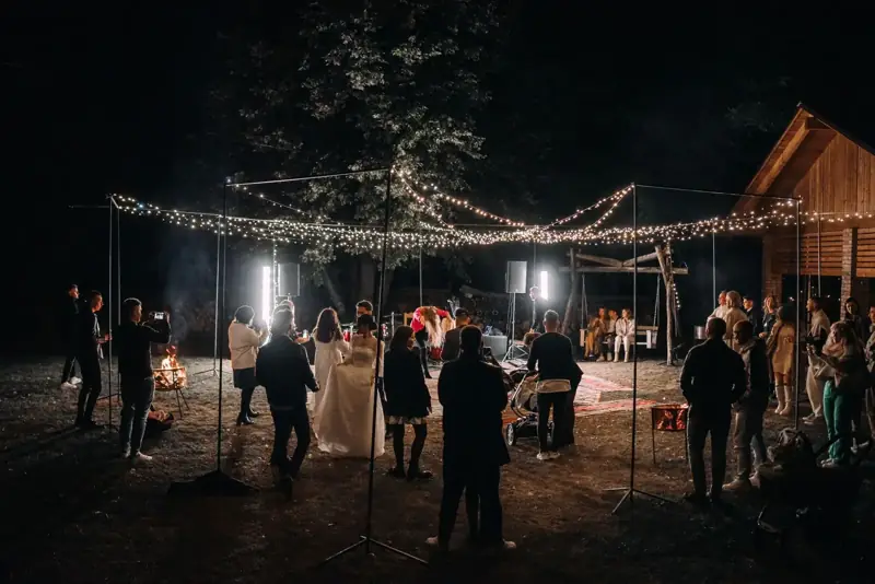 Guests at an outdoor reception under string lights